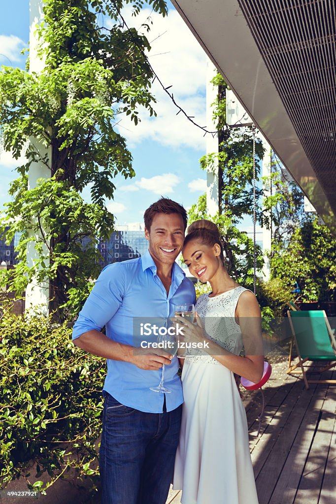 Romantic couple Outdoor portrait of flirting couple enjoying white wine on a balcony. Couple - Relationship Stock Photo