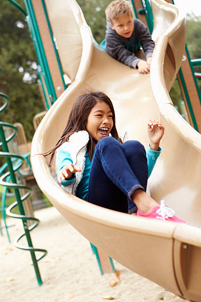 istock Young Girl Playing On Slide In Playground 494239047