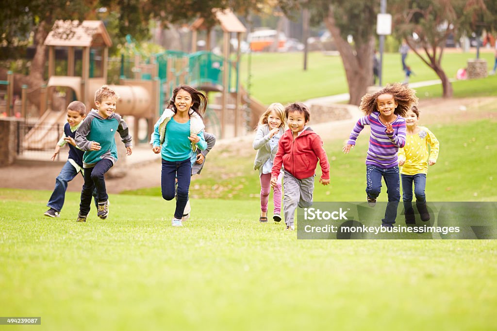 Group Of Young Children Running Towards Camera In Park Group Of Young Children Running Towards Camera In Park Smiling Child Stock Photo