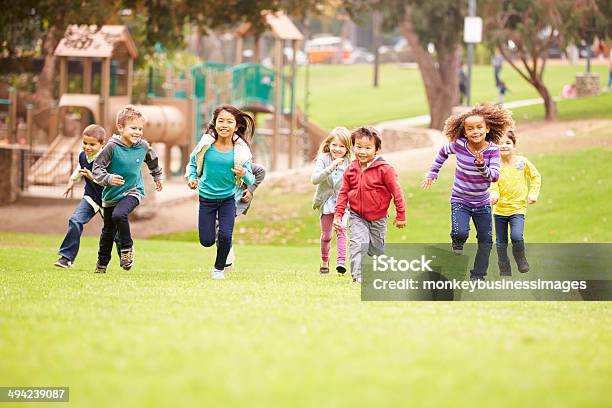 Group Of Young Children Running Towards Camera In Park Stock Photo - Download Image Now