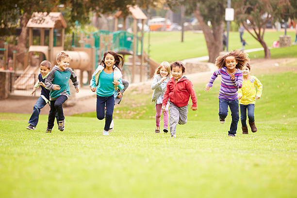 grupo de crianças a correr para a câmera no parque - elementary age child group of people togetherness imagens e fotografias de stock