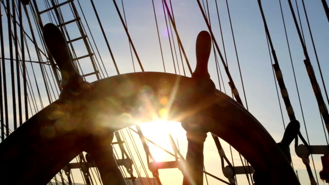 helm of a sailing ship and sun