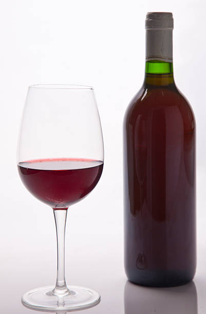istock Glass of red wine and a bottle over white background 494252300