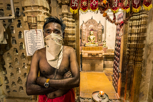 Jaisalmer, India - September 27, 2015: Jain priest inside the Jain temples complex in Jaisalmer Rajasthan India.  These buildings are built in the Dilwara style and are dedicated to Rikhabdevji and Shambhavdev Ji, the Jain hermits known as 'Tirthankars'. All of them have beautiful crafted carvings of yellow sandstones.Build from the 12th to the 15th century, this religious buildings are located within the Jaisalmer Fort.