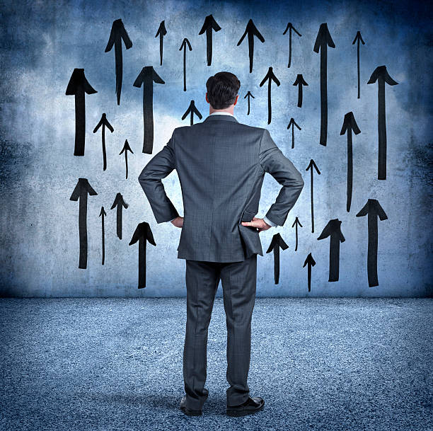 istock Businessman Looking At Arrows Pointing Up On Wall 494257048