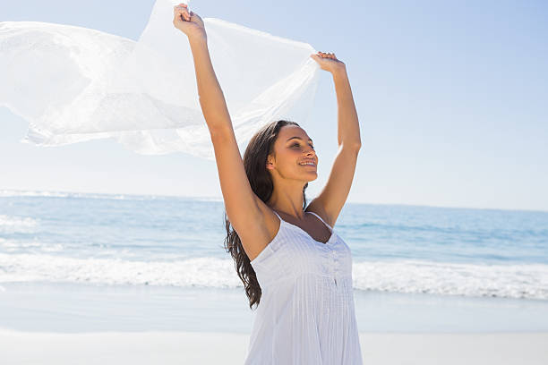 красивая брюнетка в белом платье-солнце держит парео - women sarong beach white стоковые фото и изображения