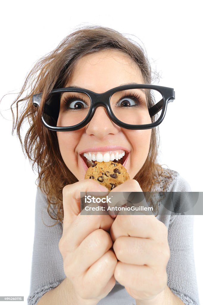 Funny geek girl eating a cookie Funny geek girl eating a cookie isolated on a white background Cookie Stock Photo