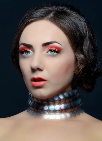 fashion woman with shiny necklace posing, eye makeup.