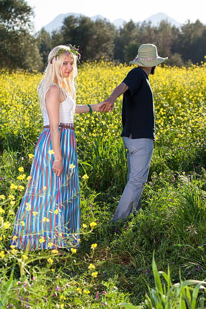 istock Young man leading his girlfriend through rapeseed. 494263455