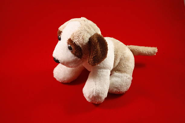 istock Speelgoed pluche hond van de zijkant met een rode achtergrond 494264271
