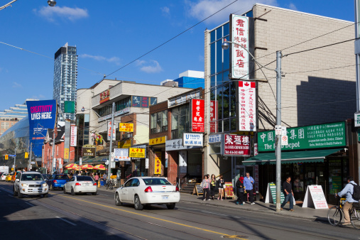 Toronto, Canada - 22nd May 2014: The outside of part of China Town on Dundas Street West in Toronto. People and traffic can be seen on the street