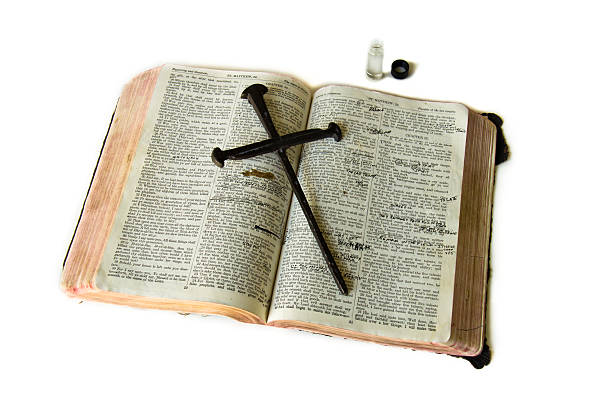 istock Old Bible with markings cross laying on top 494264633