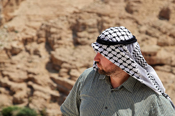istock Man wearing a keffiyeh under strong sun looking away 494276829