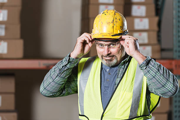 istock Man in warehouse putting on safety glasses 494276985