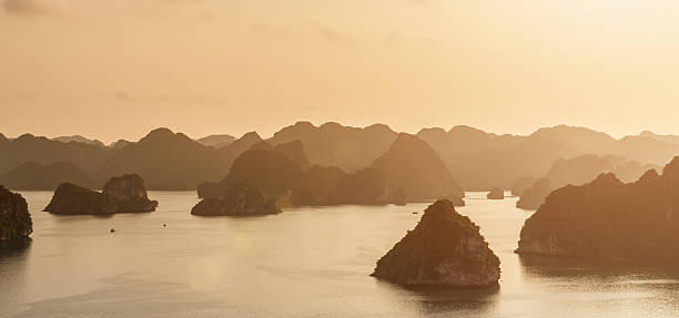 Vietnam Halong Bay Panorama Halong Bay, UNESCO world heritage site and travel destination, popular for its fantastic limestone karsts and isles at sunset. Halong Bay, Quang Ninh Province, Northern Vietnam. gulf of tonkin photos stock pictures, royalty-free photos & images