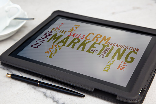 tablet with CRM marketing word cloud