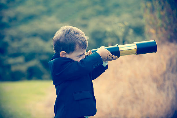 istock Young boy in a business suit with telescope. 494279086