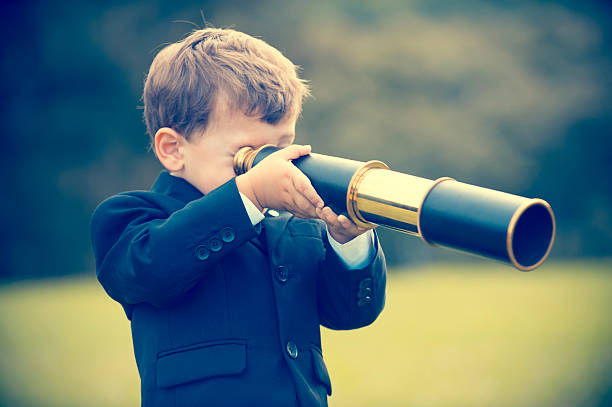 istock Young boy in a business suit with telescope. 494279156