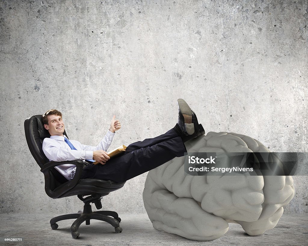 Business education Young handsome businessman sitting in chair and reading book Achievement Stock Photo