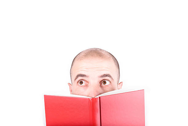 istock Young man funny face behind the book 494281432
