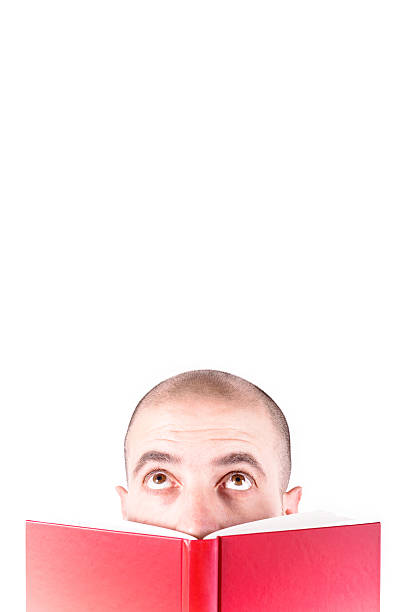 istock Young man behind a red book looking up. blank space 494281666
