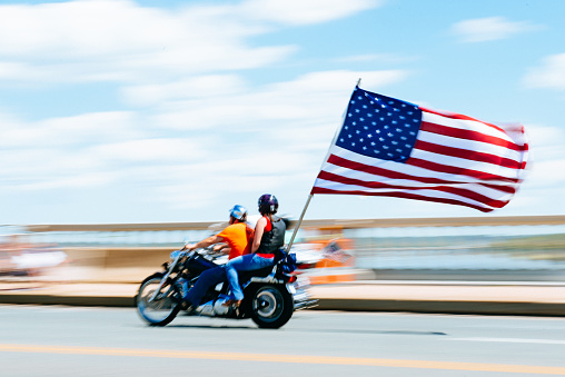 Washington DC, United States - May 25, 2014: Motorbike displaying american flag crosses the Arlington Memorial Bridge during the Rolling Thunder Ride on Memorial Day. Rolling Thunder is an annual motorcycle rally held annually in Washington DC to honor war heroes.