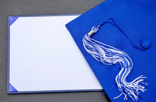 Cap, tassel and blank diploma with copy space for your congratulatory message or invitation.