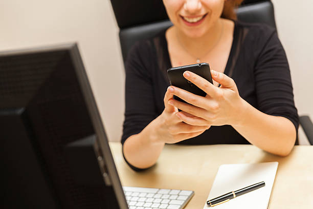 istock Smiling Young Woman Using Her Smart Phone in the Office 494283326