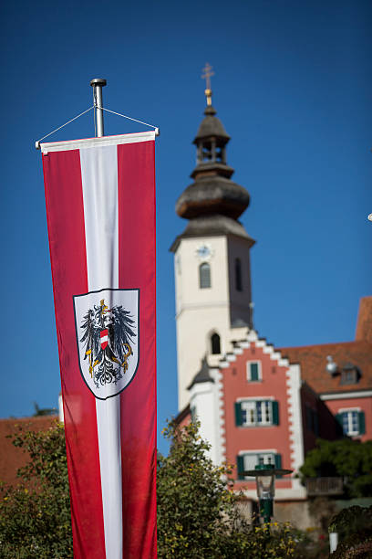 austrian flag and emblem in frohnleiten,styria church in frohnleiten,styria,austria with austrian flag and crest,emblem called Bundesadler frohnleiten stock pictures, royalty-free photos & images