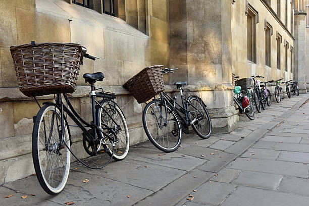 Cambridge University Bicycles Traditional bicycles with baskets parked by students in a Cambridge street near a college cambridgeshire photos stock pictures, royalty-free photos & images