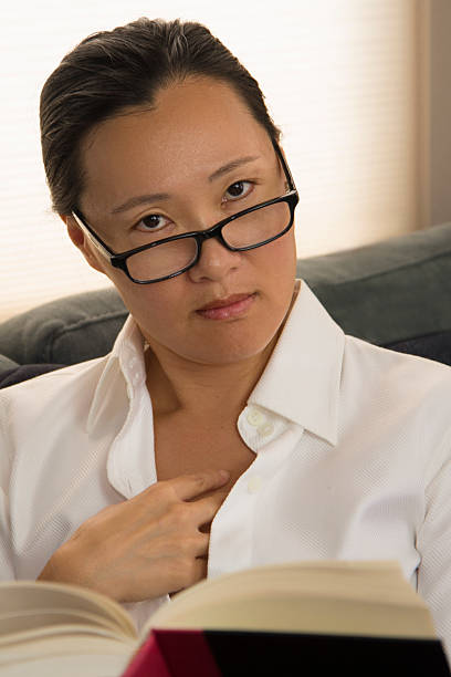 istock Asian Woman Looks Up from Her Book 494287992