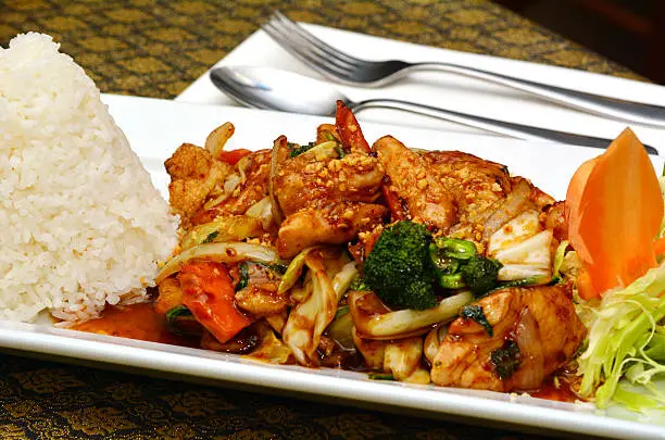 Thai chicken cashew served with jasmine rice on a plate.