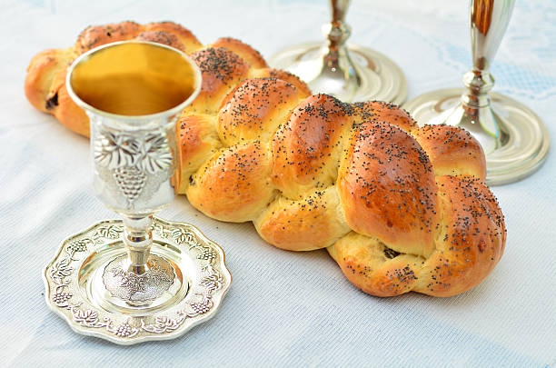 Shabbat eve table Shabbat eve table with uncovered challah bread, Sabbath candles and Kiddush wine cup. jewish sabbath photos stock pictures, royalty-free photos & images