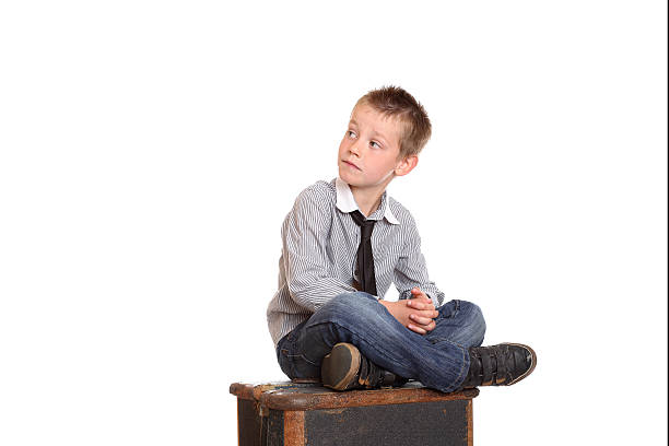 Young boy sat cross-legged stock photo