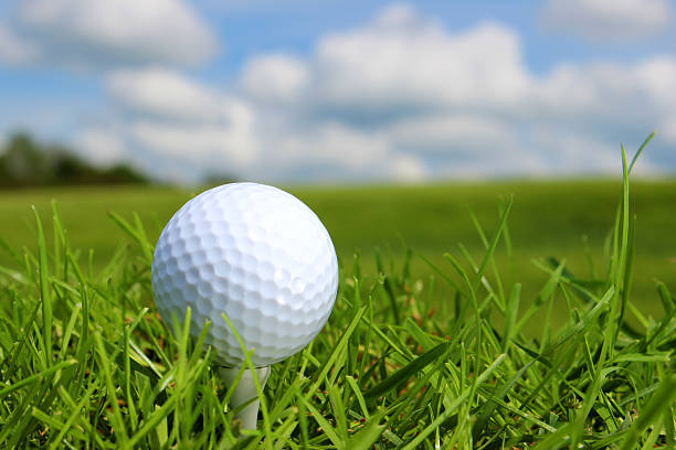 istock Close-up golf ball in grass on golf course, blue sky 494298125