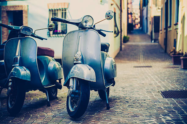 Two Vespa Scooter in Italy Italian urban scene with a Vespa, a very typical italian motorcycle moped stock pictures, royalty-free photos & images