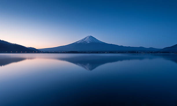 mountain Fuji at dawn with peaceful lake reflection stock photo