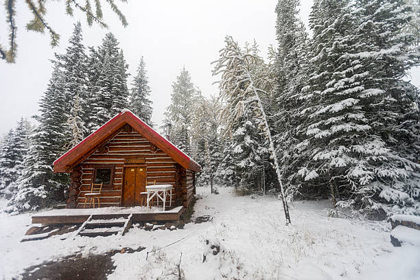 Fantastic winter landscape with glowing wooden cabin in snowy forest. Cozy house in Carpathian mountains. Christmas holiday concept