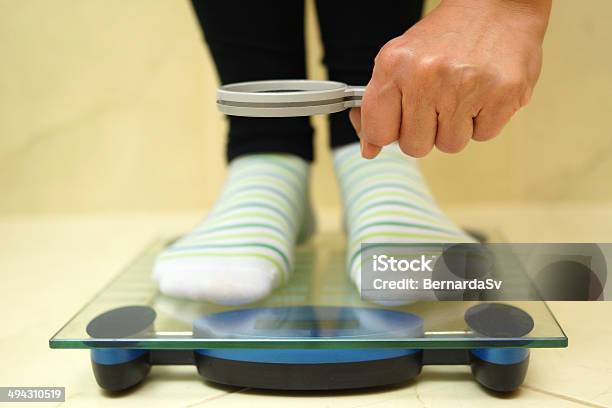 Woman Feet On Weighing Scales Looking Weight Over Magnifying Stock Photo - Download Image Now