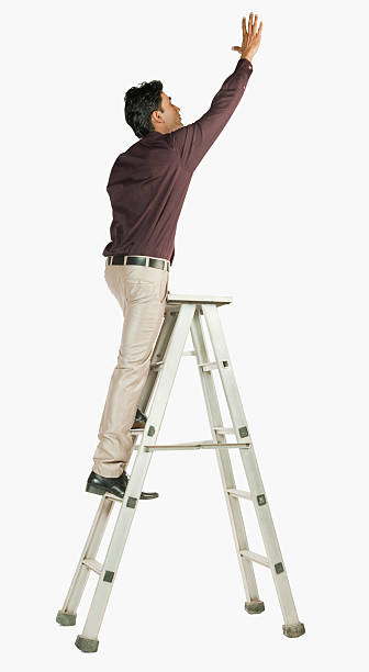 Businessman on a ladder stock photo