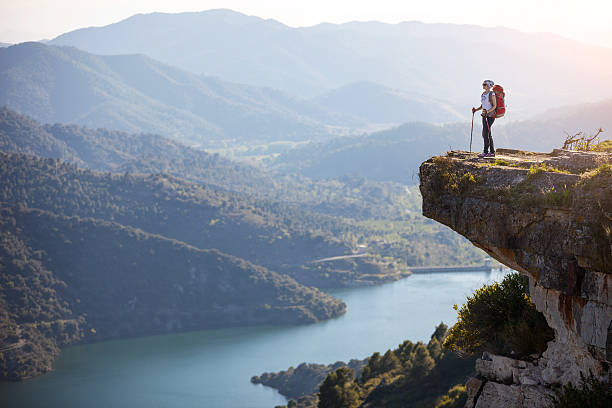 Female hiker standing on cliff stock photo