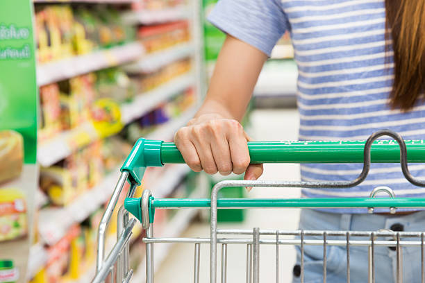 Woman with shopping cart in supermarket. stock photo