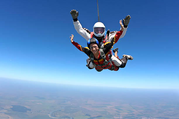 Skydiving photo. Tandem. Tandem jump. The girl with the instructor in freefall. skydiving stock pictures, royalty-free photos & images
