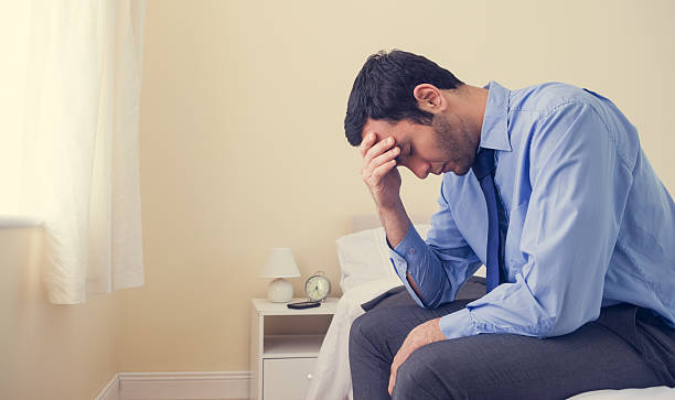 istock Depressed man sitting head in hands on his bed 494312203