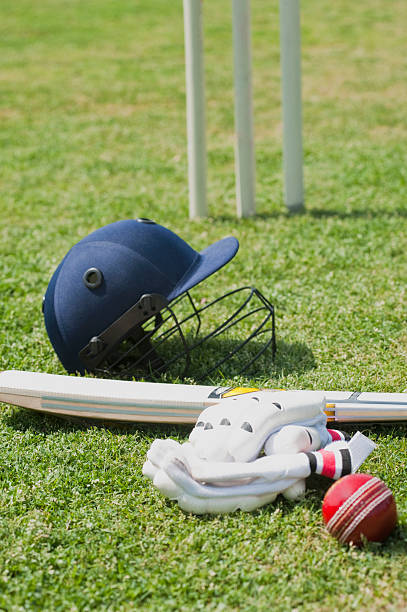 Cricket batting gears in a field stock photo