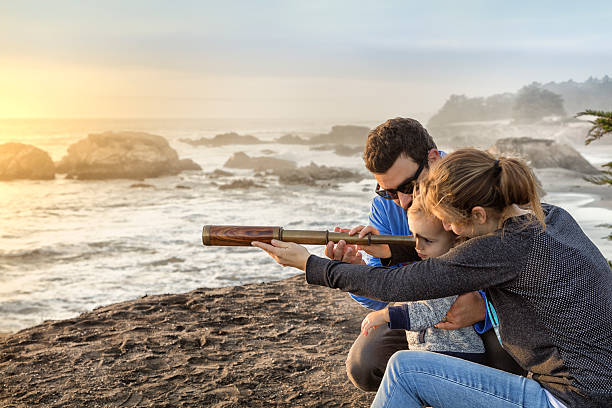 istock Family with spyglass looking toward ocean 494312862