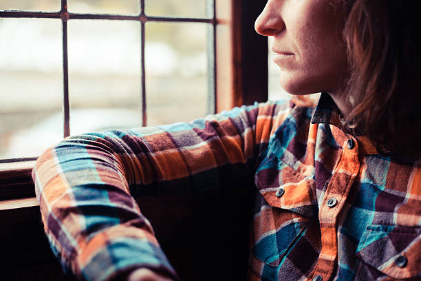 istock Young woman looking out the window 494313307