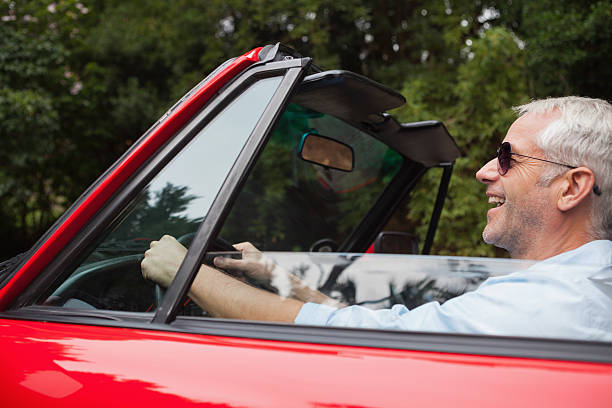istock Smiling handsome man driving red convertible 494314361