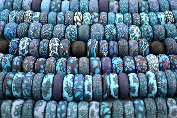 Millefiori polymer clay beads in rows Close up  of blue millefiori polymer clay beads in rows polymer clay stock pictures, royalty-free photos & images