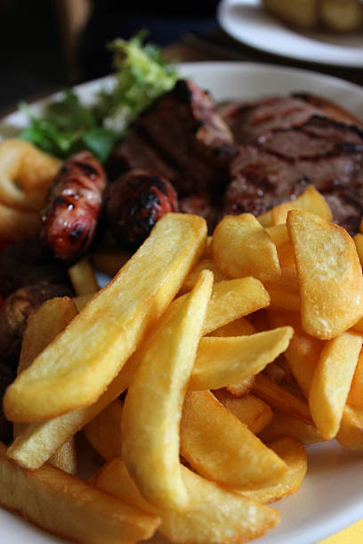 istock Mixed grill meal in restaurant, with steak, sausages, gammon, chips 494315369